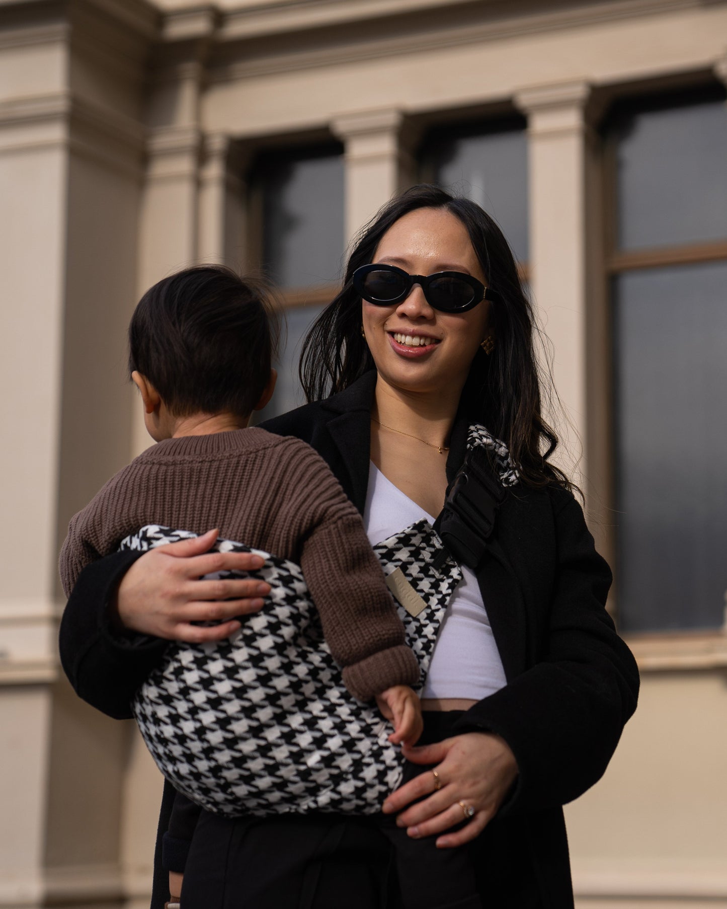 Parent holding toddler in the Cuddl.bub Toddler Carrier/Toddler Sling Black Houndstooth
