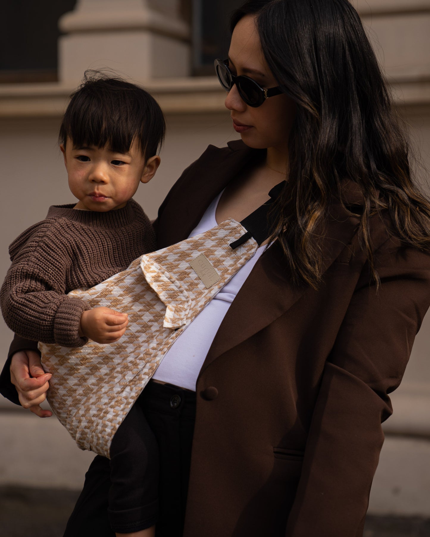 Parent carrying toddler carrier/toddler sling outdoors