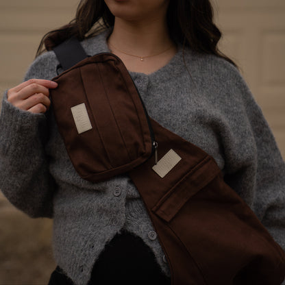 toddler parent wearing a chocolate brown/cocoa toddler carrier/toddler sling with a chocolate brown/cocoa slide on pouch